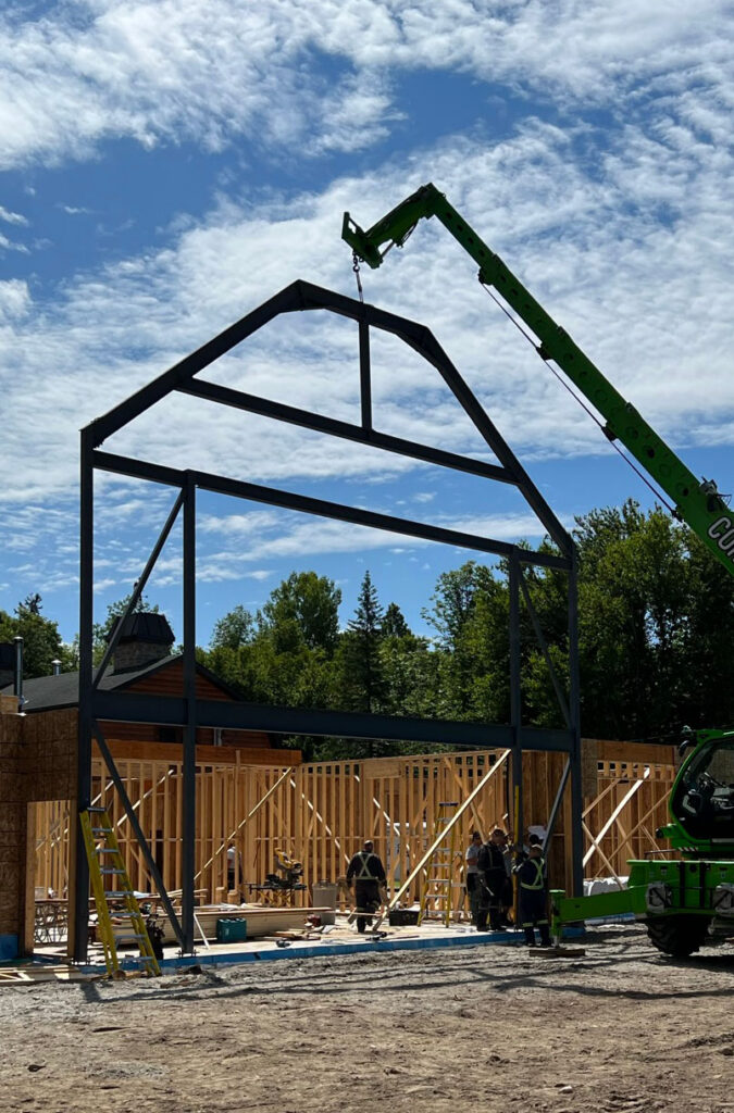 Installation d’un portique en acier à l’aide d’une grue sur un chantier de construction