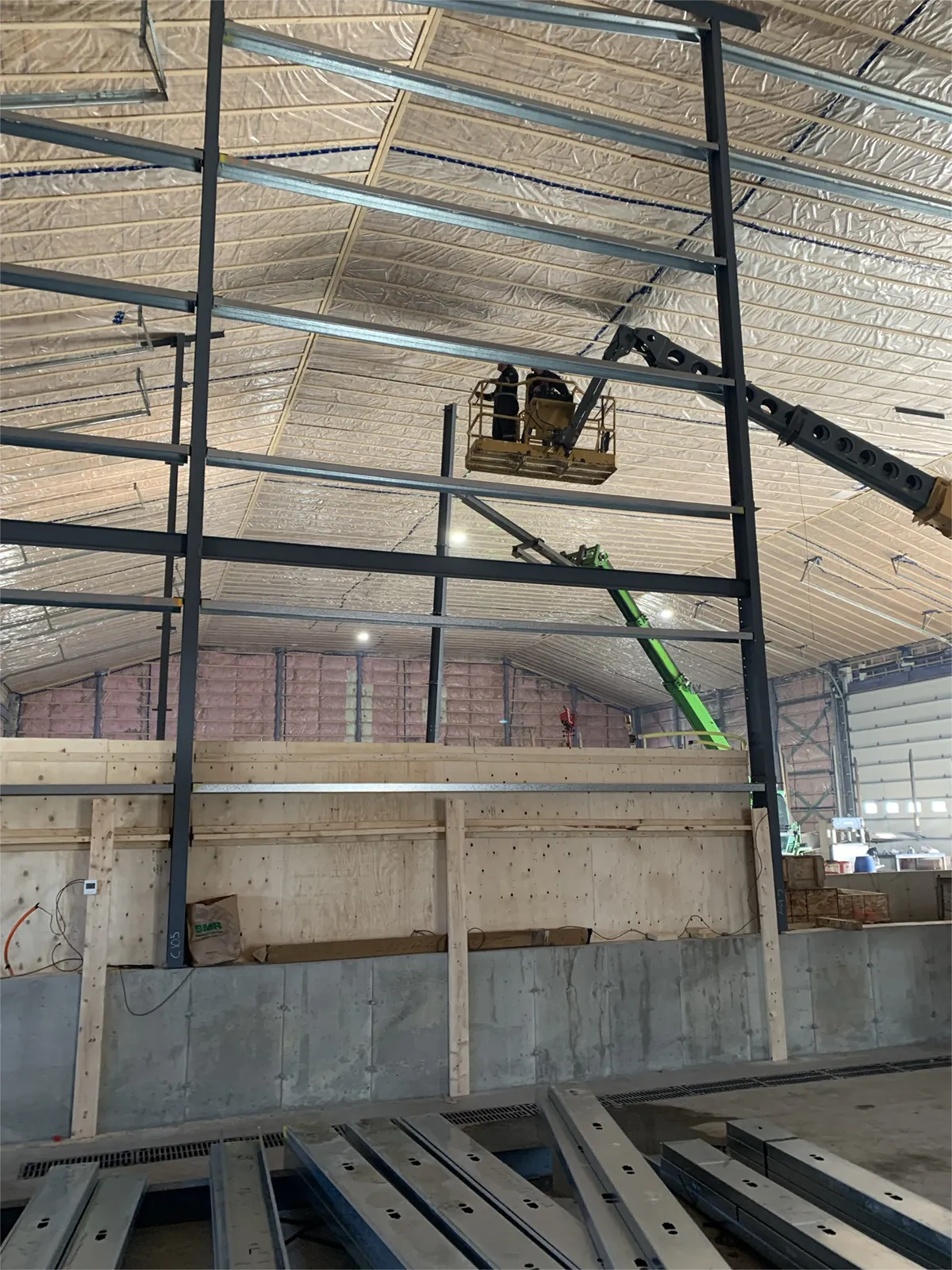 Travailleurs installant une structure d’acier à l’intérieur d’un bâtiment commercial