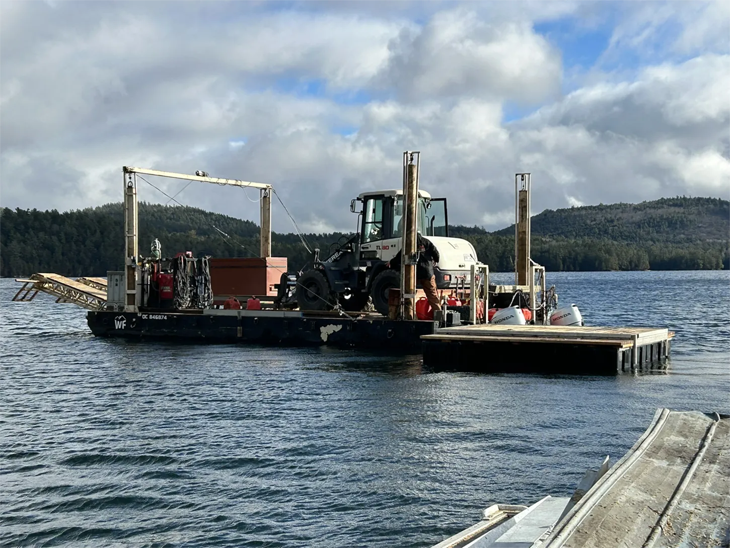 Plateforme de travail flottante avec machinerie et équipement industriel sur un lac